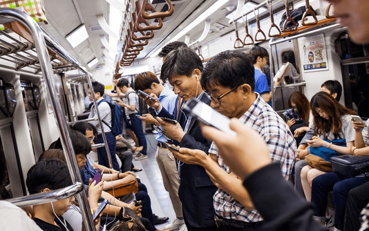 A photograph of subway riders in South Korea reading smartphones.